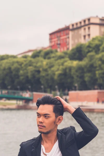 Handsome Asian model posing by an artificial basin — Stock Photo, Image