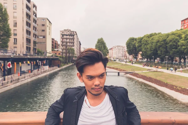 Handsome Asian model posing by an artificial basin — Stock Photo, Image