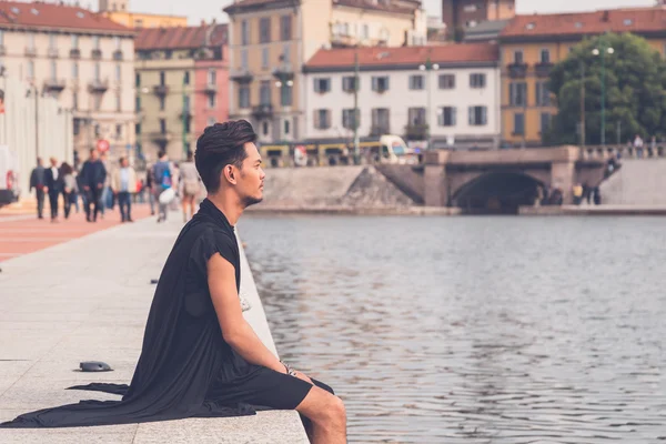 Hübsche asiatische Modell sitzen durch ein künstliches Becken — Stockfoto