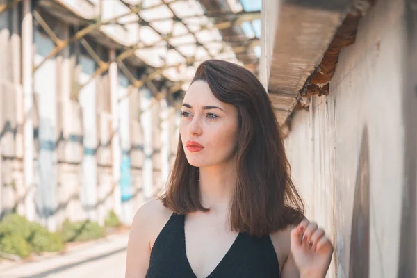 Beautiful brunette posing in an industrial context — Stock Photo, Image