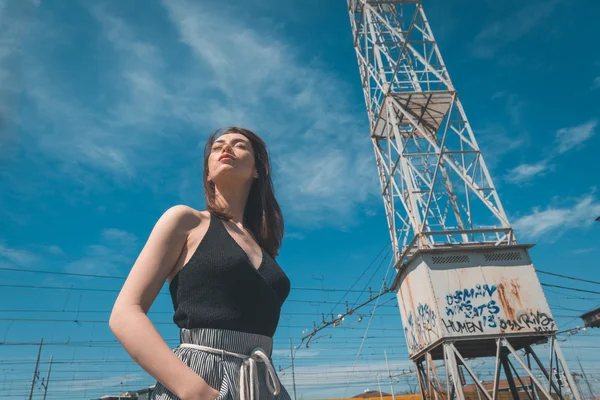 Hermosa morena posando en un contexto industrial — Foto de Stock