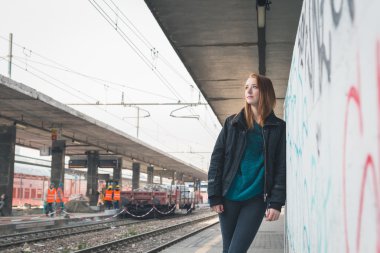 Güzel kız bir demiryolu istasyonunda poz