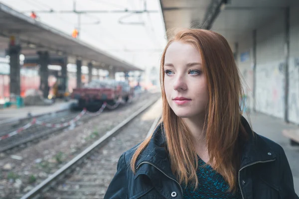 Vacker flicka poserar i en järnvägsstation — Stockfoto