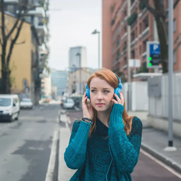 Beautiful girl listening to music in the city streets — Stock Photo, Image