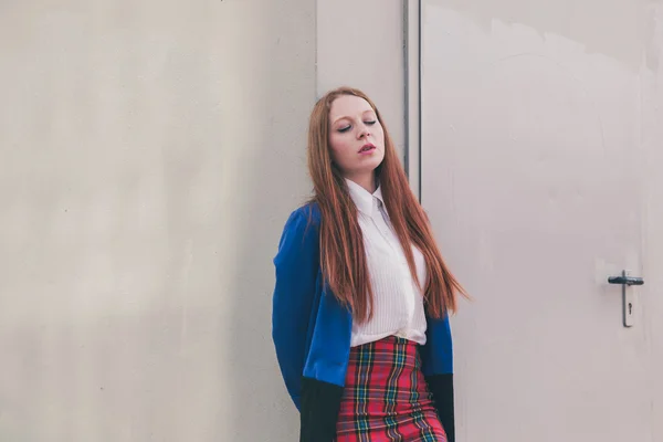 Menina ruiva bonita posando em um contexto urbano — Fotografia de Stock