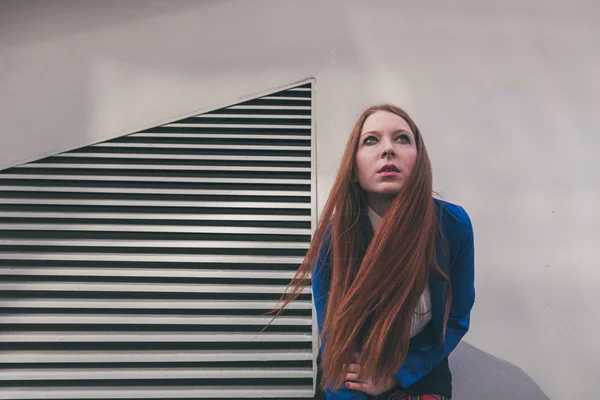 Menina ruiva bonita posando em um contexto urbano — Fotografia de Stock