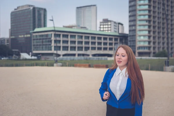 Beautiful redhead girl posing in an urban context — Stock Photo, Image