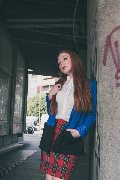 Beautiful redhead girl posing in an urban context — Stock Photo, Image