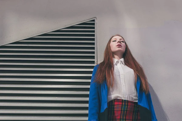 Menina ruiva bonita posando em um contexto urbano — Fotografia de Stock