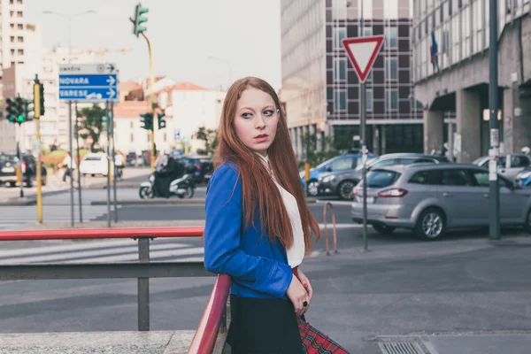 Bella rossa ragazza in posa in un contesto urbano — Foto Stock