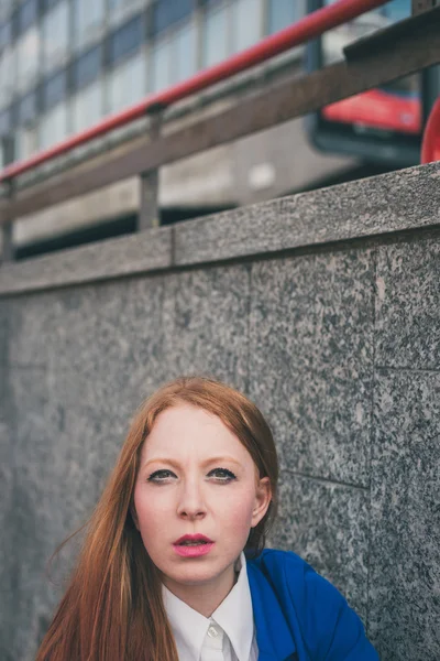 Menina ruiva bonita posando em um contexto urbano — Fotografia de Stock