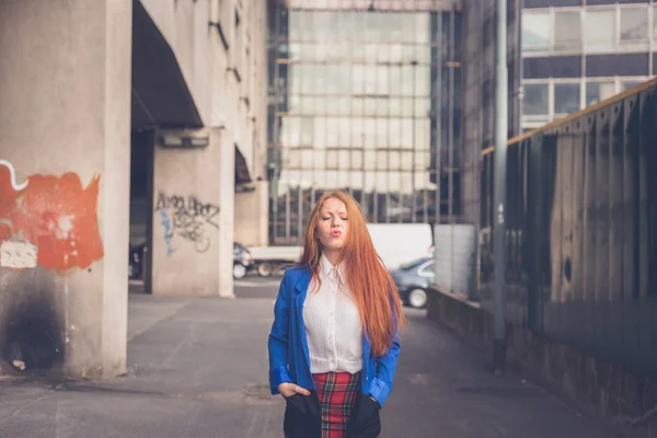 Menina ruiva bonita posando em um contexto urbano — Fotografia de Stock