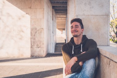 Genç adam bir kentsel bağlamda poz