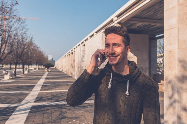 Jeune bel homme parlant au téléphone — Photo