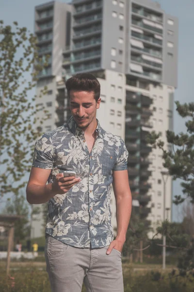 Young handsome man texting in the street — Stok fotoğraf