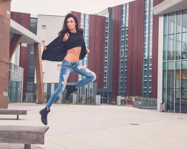 Beautiful girl jumping from a bench — Stock Photo, Image