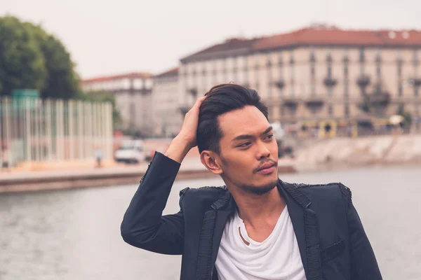 Handsome Asian model posing by an artificial basin — Stock Photo, Image