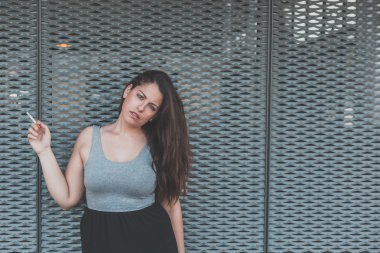 Bir sigara bir kentsel bağlamda güzel curvy kız