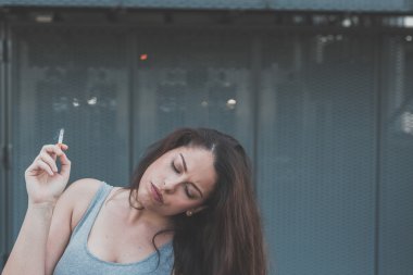 Bir sigara bir kentsel bağlamda güzel curvy kız