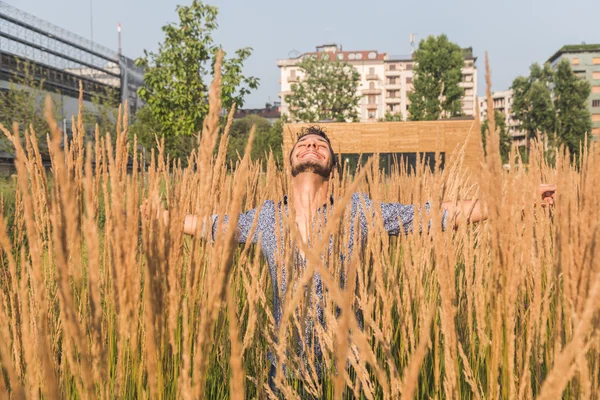 Joven hombre guapo posando en un campo — Foto de Stock