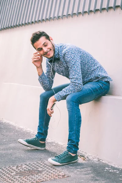 Young handsome man listening to music in the city streets — Stock Photo, Image