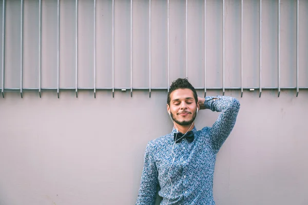 Joven hombre guapo escuchando música en las calles de la ciudad — Foto de Stock