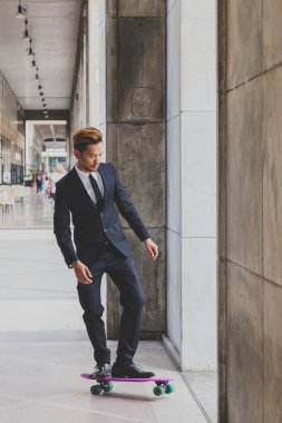 Genç yakışıklı Asya model kaykayıyla poz