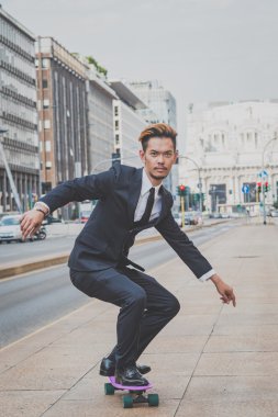 Genç yakışıklı Asya modeli onun kaykay sürme