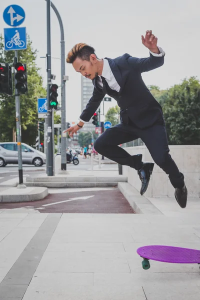 Young handsome Asian model jumping with his skateboard — Stock Photo, Image
