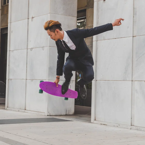 Young handsome Asian model jumping with his skateboard — Stock Photo, Image