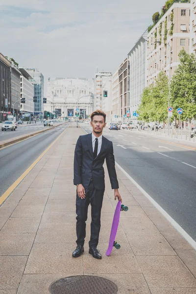 Young handsome Asian model posing with his skateboard — Stock Photo, Image