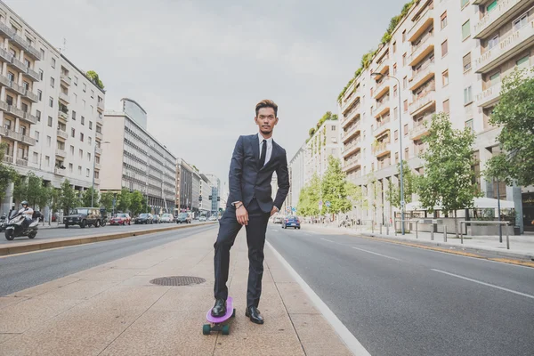 Young handsome Asian model posing with his skateboard — Stock Photo, Image