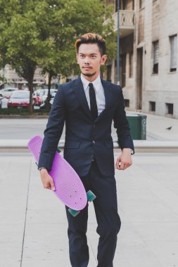 Genç yakışıklı Asya model kaykayıyla poz