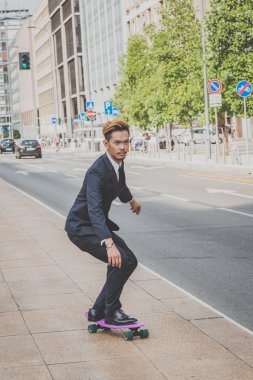 Genç yakışıklı Asya modeli onun kaykay sürme