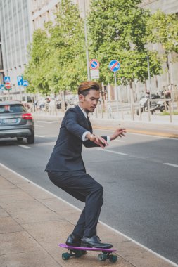 Genç yakışıklı Asya modeli onun kaykay sürme