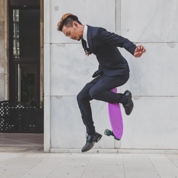 Young handsome Asian model jumping with his skateboard — Stock Photo, Image