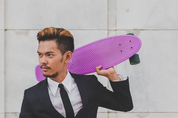 Young handsome Asian model posing with his skateboard — Stock Photo, Image