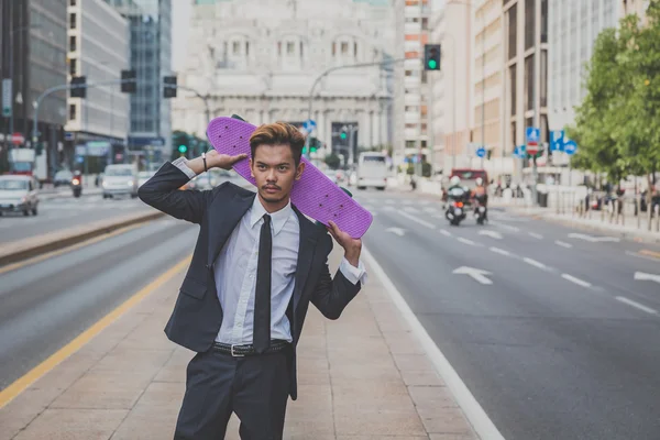 Young handsome Asian model posing with his skateboard — Stock Photo, Image