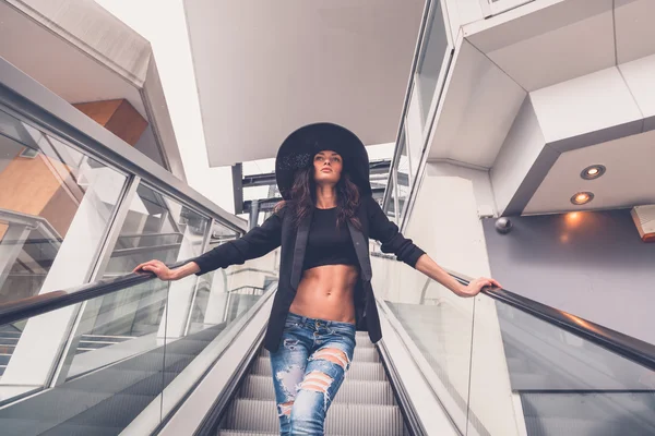 Schöne Mädchen posiert auf einer Rolltreppe — Stockfoto