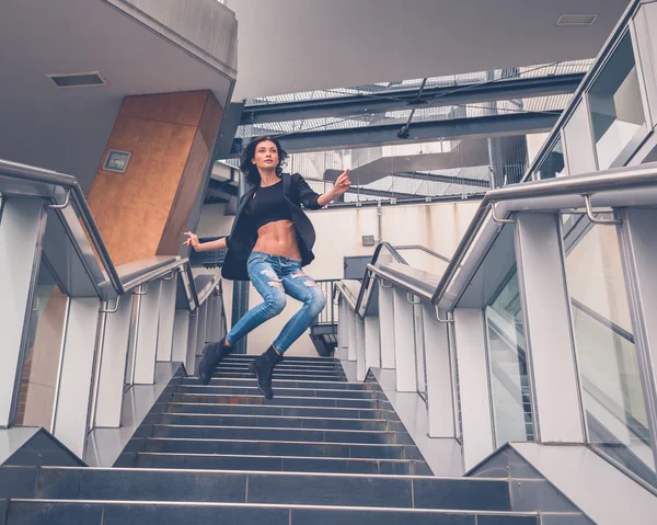 Beautiful girl jumping from a staircase — Stock Photo, Image