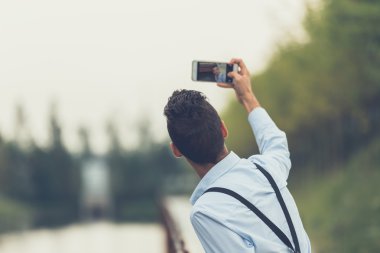 Yakışıklı delikanlı bir nehir kenarında bir selfie alarak