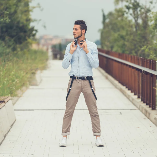 Joven hombre guapo posando en un contexto urbano — Foto de Stock