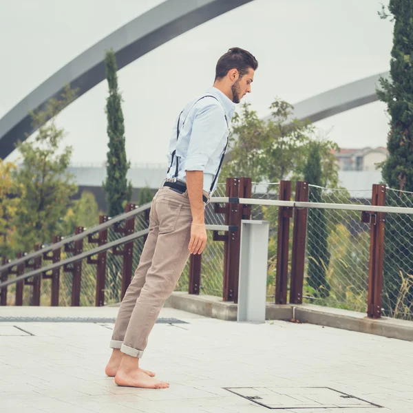 Joven hombre guapo posando en un contexto urbano — Foto de Stock