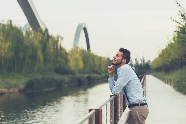 Joven hombre guapo posando en un contexto urbano — Foto de Stock