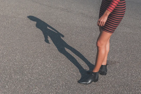 Egy gyönyörű lány pózol egy városi környezet árnyékában — Stock Fotó