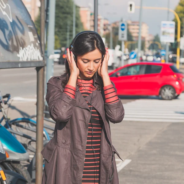 Beautiful girl listening to music in an urban context — Stock Photo, Image