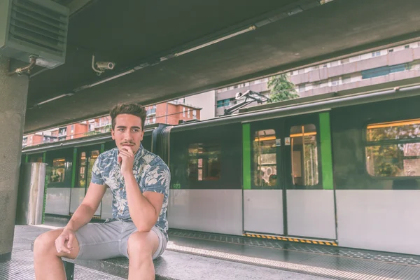 Молодой красивый мужчина позирует в метро — стоковое фото
