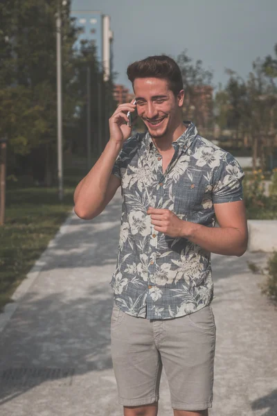 Joven hombre guapo hablando por teléfono en la calle — Foto de Stock