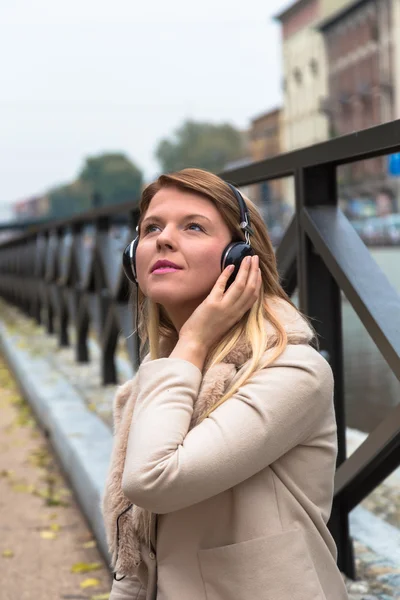 Gyönyörű lány zenehallgatás fejhallgató egy városi Co — Stock Fotó
