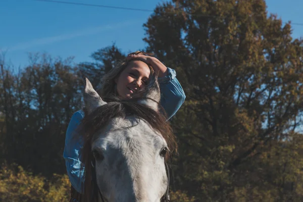 Bella ragazza cavalcando il suo cavallo grigio — Foto Stock